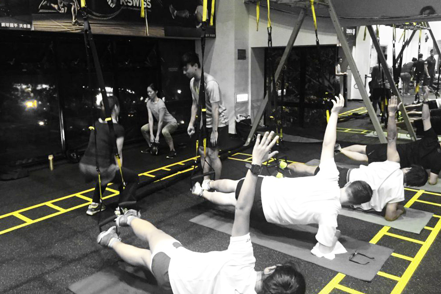 TRX懸掛式訓練課程課程，此組圖有四張照片，照片內容為學員學習動作，雙腳放在掛勾手撐地，雙手撐在掛勾身體前傾訓練平衡