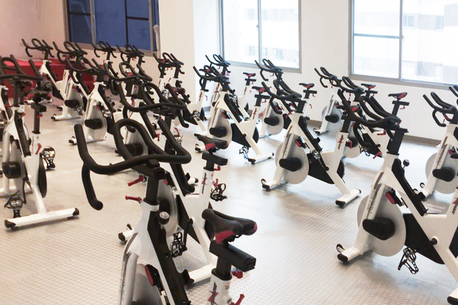 飛輪課程課程,此組圖有二張照片,照片內容為對教室的設備拍照,還有導師在指導年輕學員動作